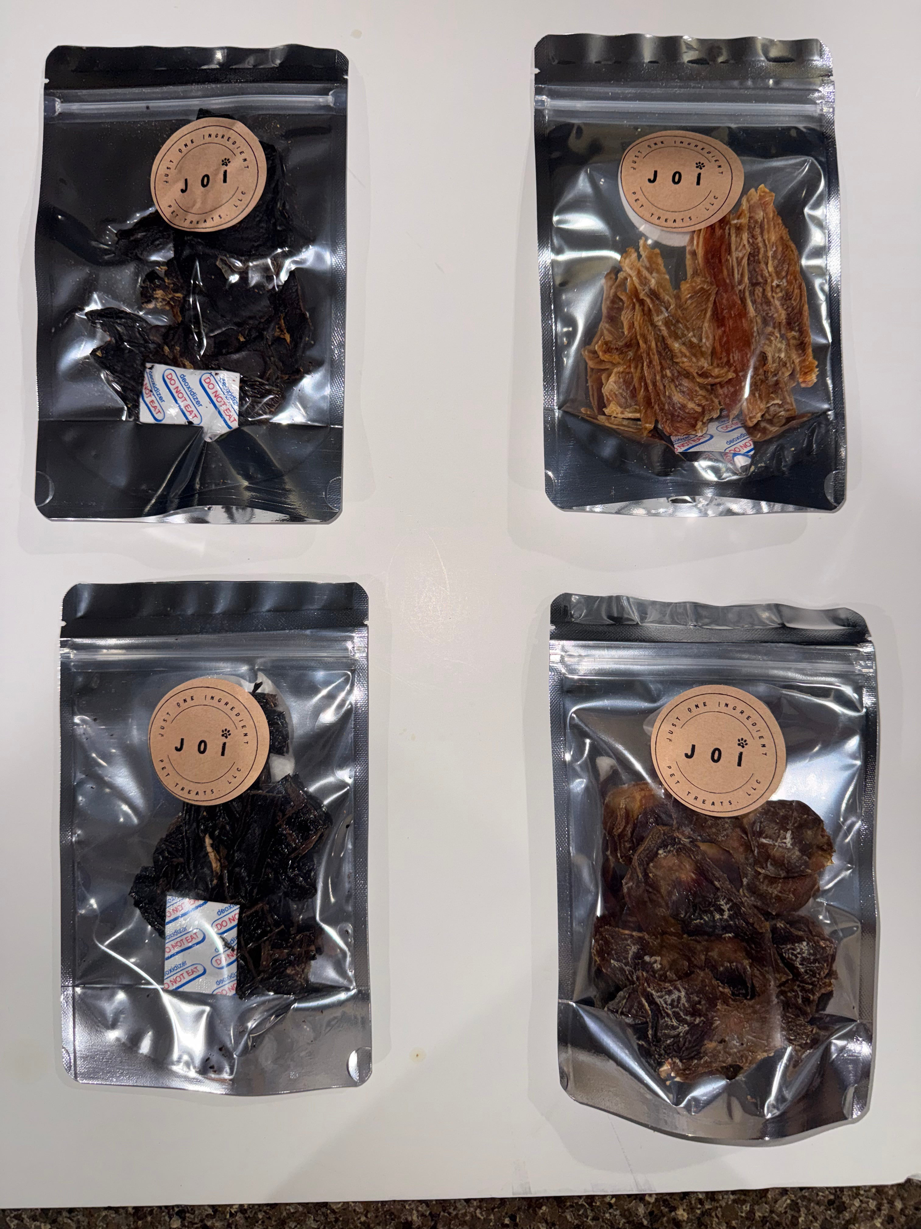 Four packages of treats with JOI label on a white background